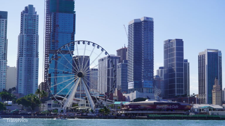 Skyline von Downtown Miami mit Riesenrad und Hochhäusern am Wasser.