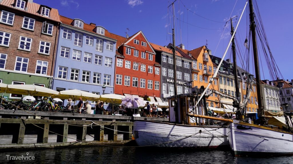 Bunte Häuser und ein Segelboot am Nyhavn in Kopenhagen.