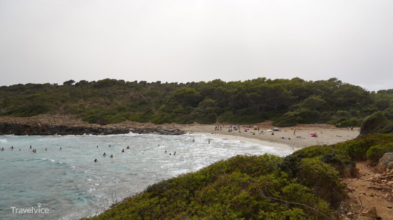 Sandstrand und klares Wasser in der von Felsen eingerahmten Cala Varques