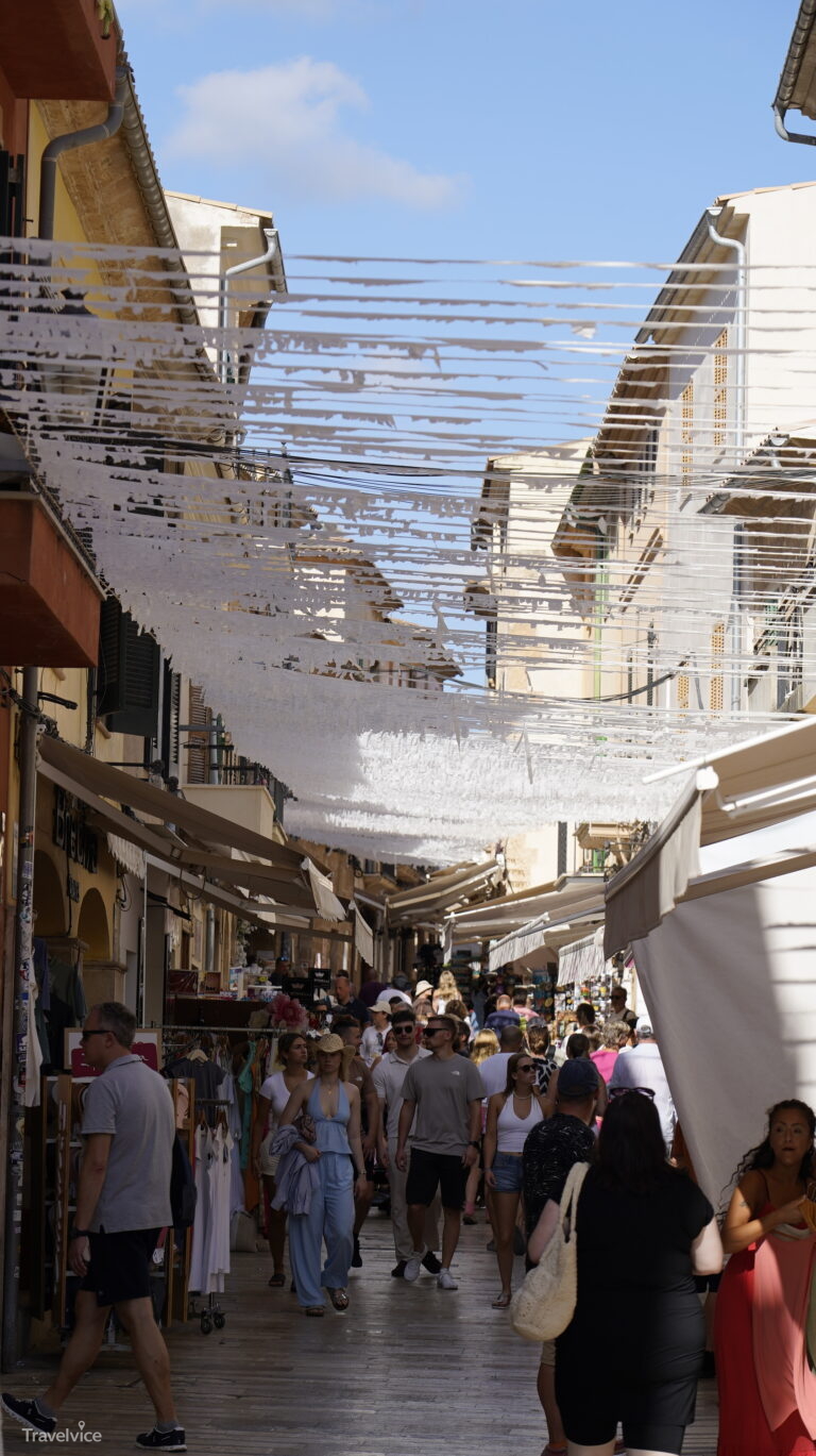 Schmale Altstadtgasse mit Marktständen und Sonnensegeln in Alcúdia
