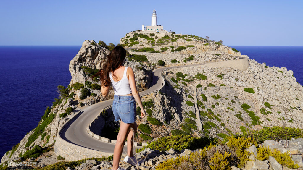 Frau am Aussichtspunkt mit Blick zum Leuchtturm von Formentor