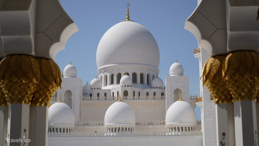Blick durch einen verzierten Bogen auf die Sheikh Zayed Grand Mosque